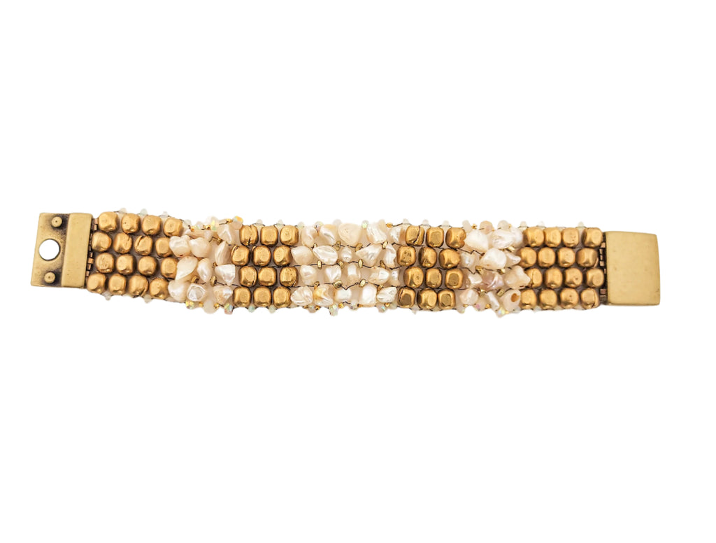 Gold and pearl beaded bracelet on a light background