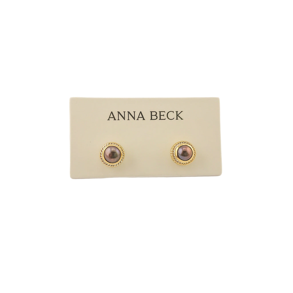 Pair of earrings on a 'Anna Beck' branded card against a beige background