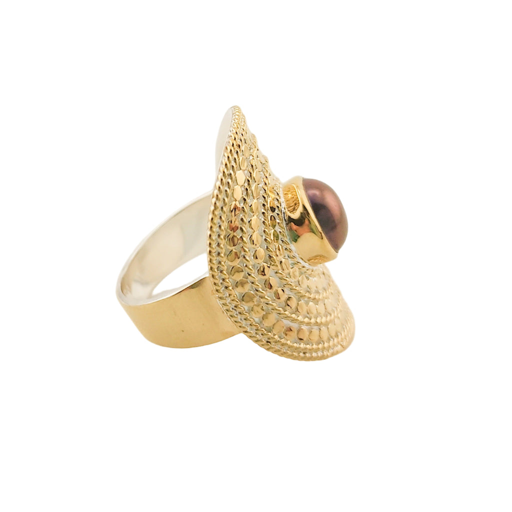 Gold ring with a textured design on a light background