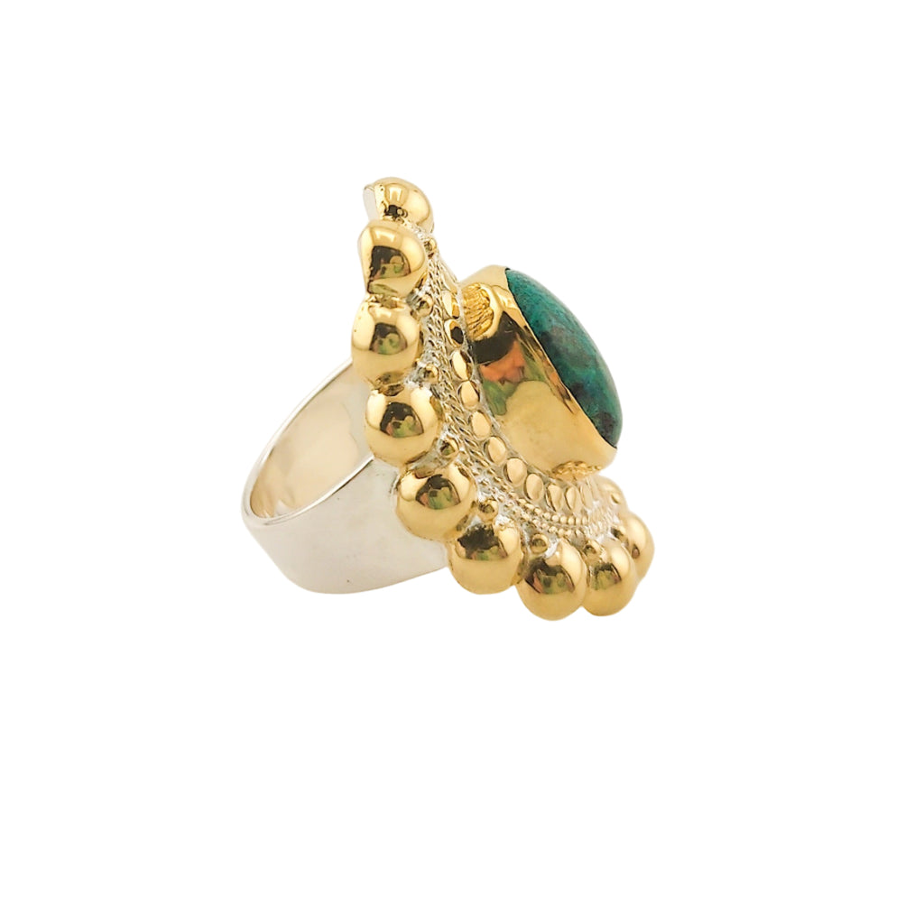 Gold ring with a green gemstone on a white background, side view