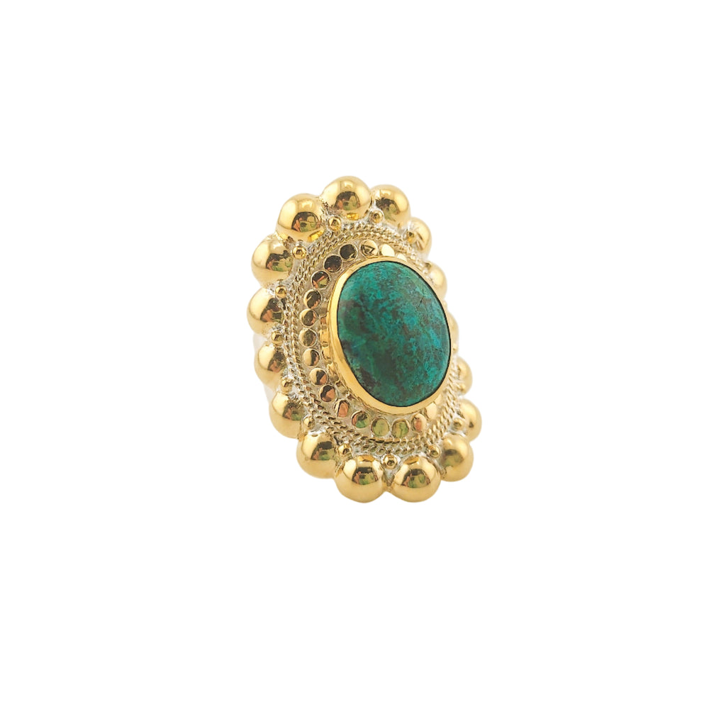 Gold ring with a green gemstone on a white background