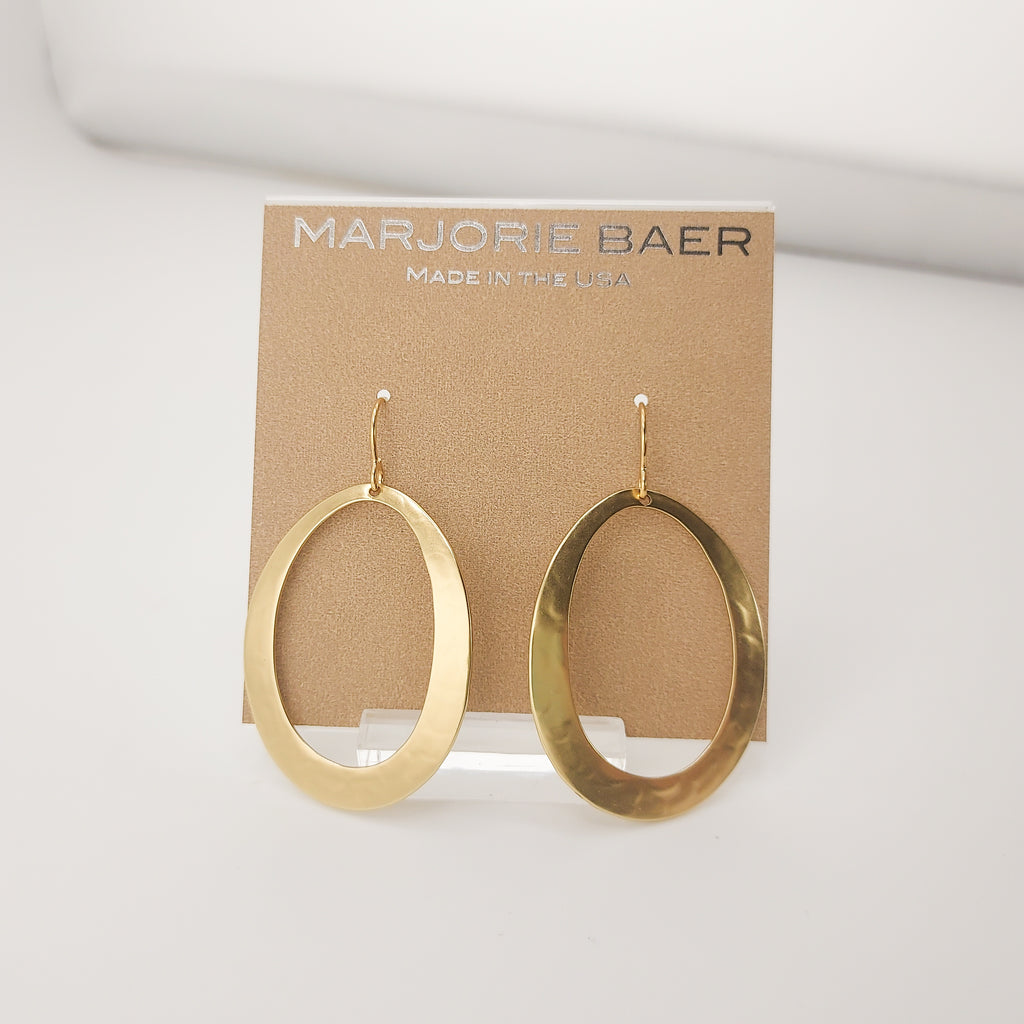 Gold hoop earrings on a Marjorie Baer branded card against a white background