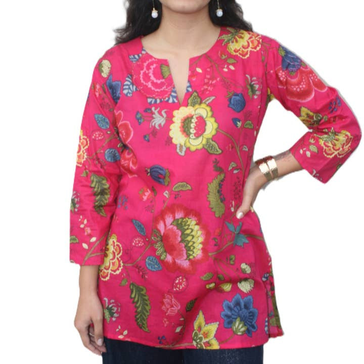 Woman wearing a pink floral embroidered top on a white background