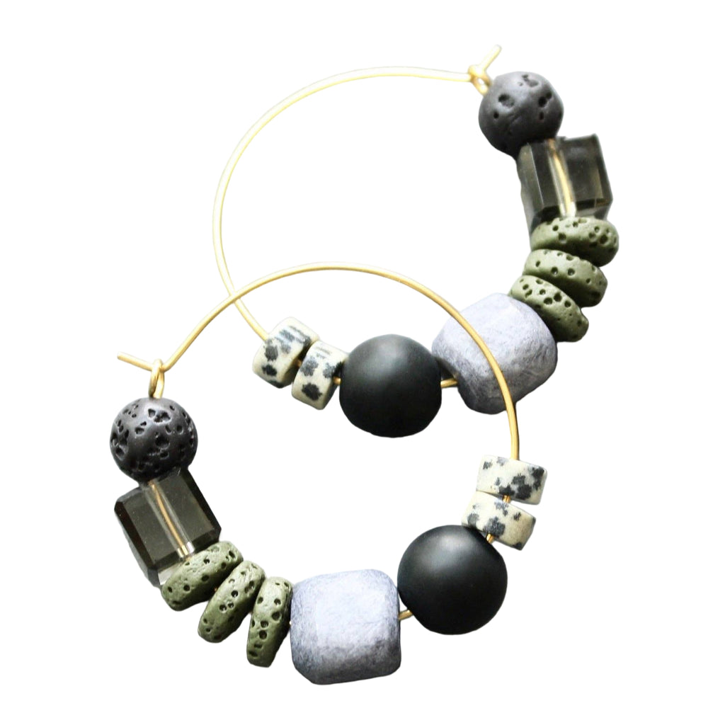 Pair of hoop earrings with black, gray, and white beads on a light gray background