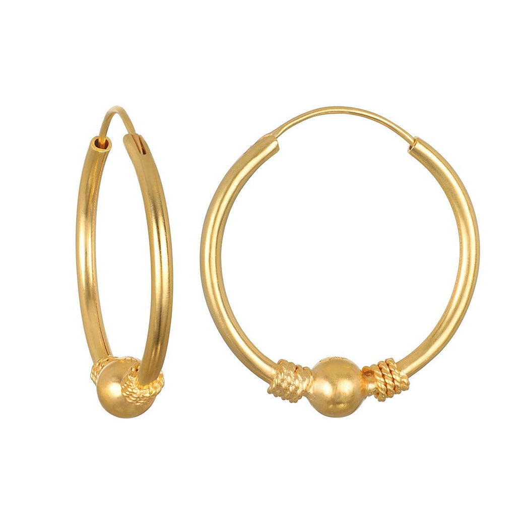 Gold hoop earrings with spherical ends on a white background