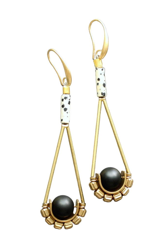 Gold and black earrings on a light gray background