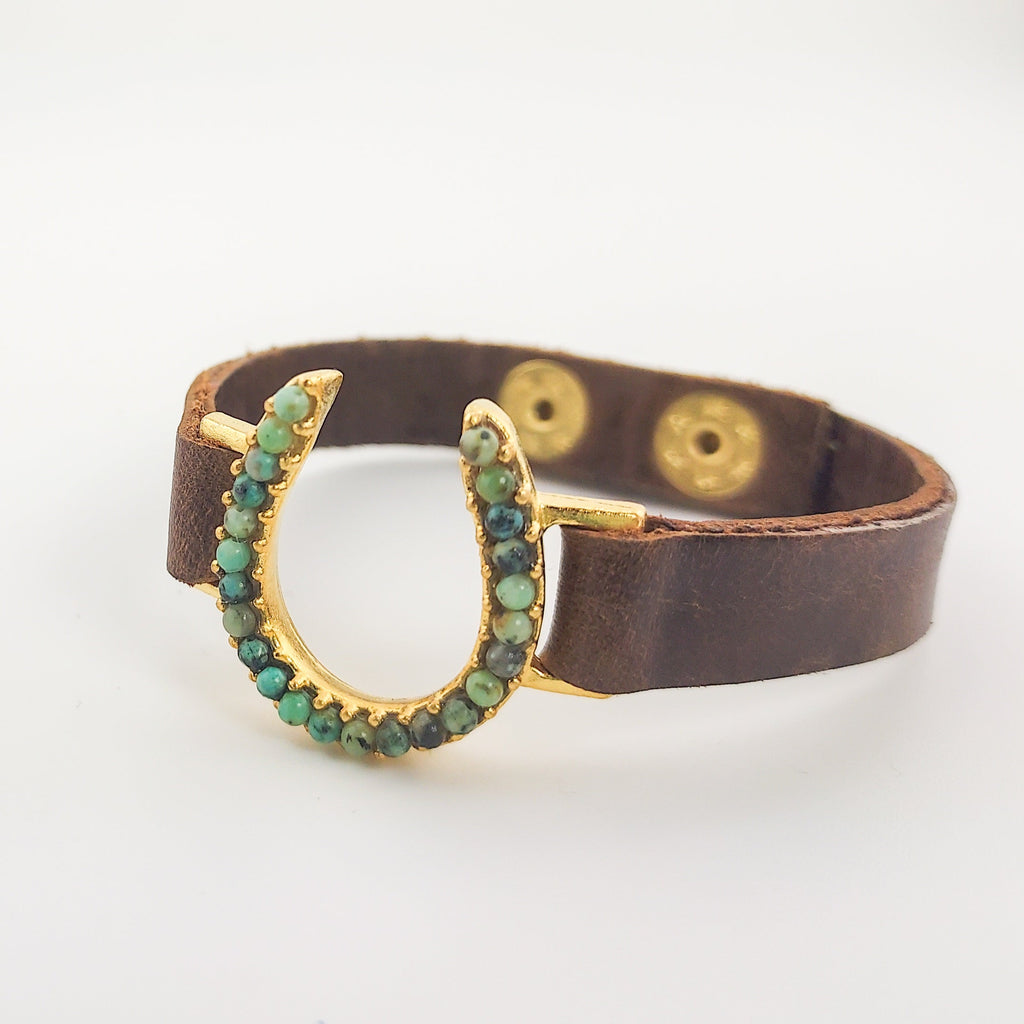 African Turquoise Horseshoe Leather Bracelet in Gold over off white background
