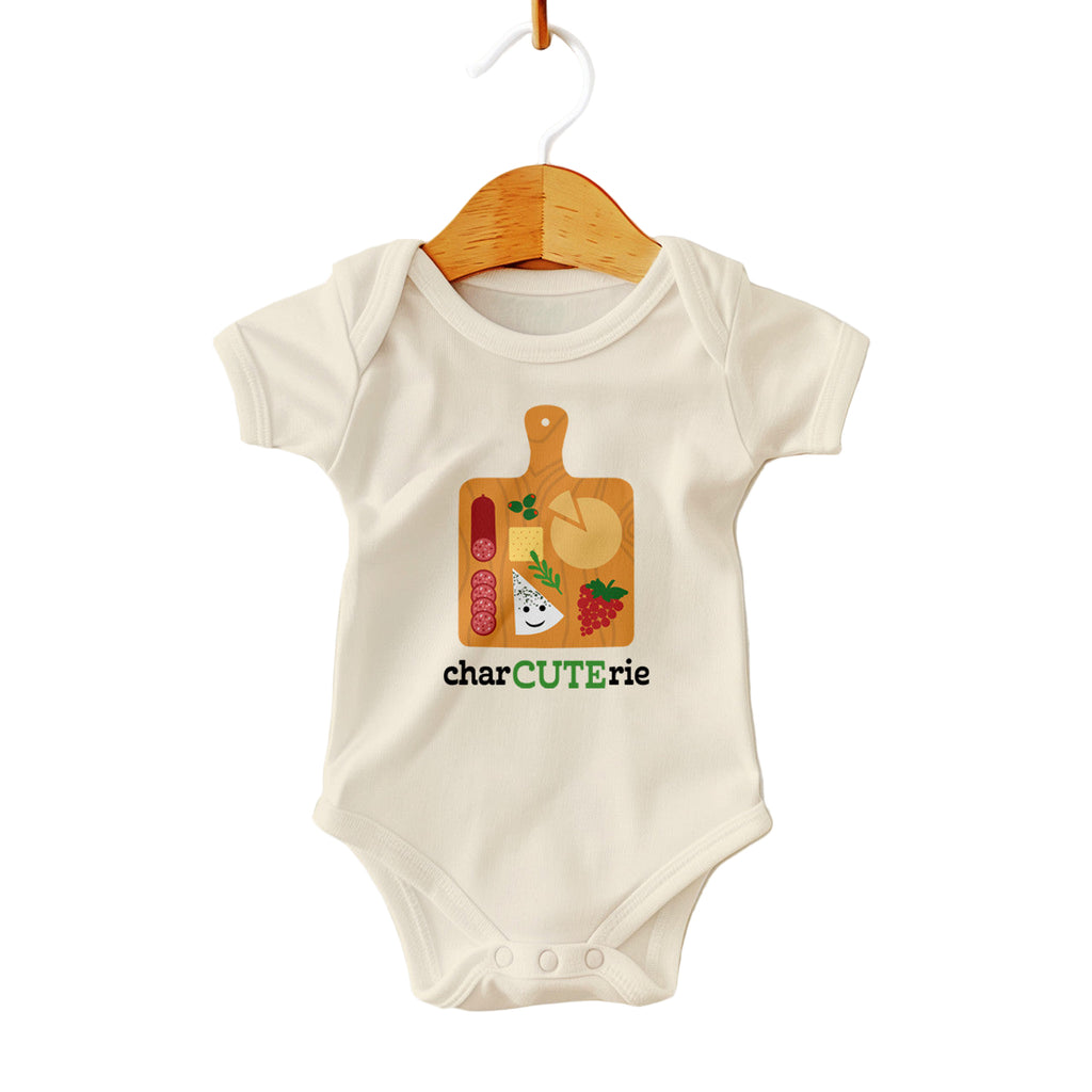 Baby onesie with charcuterie design on a hanger against a white background