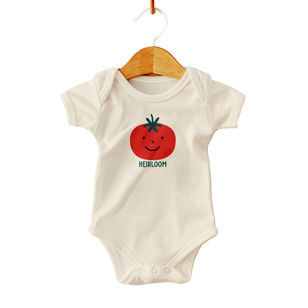 Baby onesie with a tomato graphic and 'HEIRLOOM' text on a white background