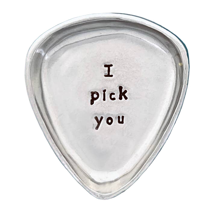 Silver guitar pick with 'I pick you' engraving on a blue background