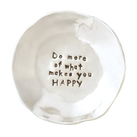 A white ceramic bowl with the text 'Do more of what makes you HAPPY' in the center.