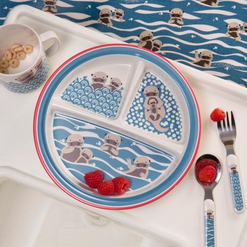 Children's plate with otter design, cup, and utensils on a tray with a sea-themed background.