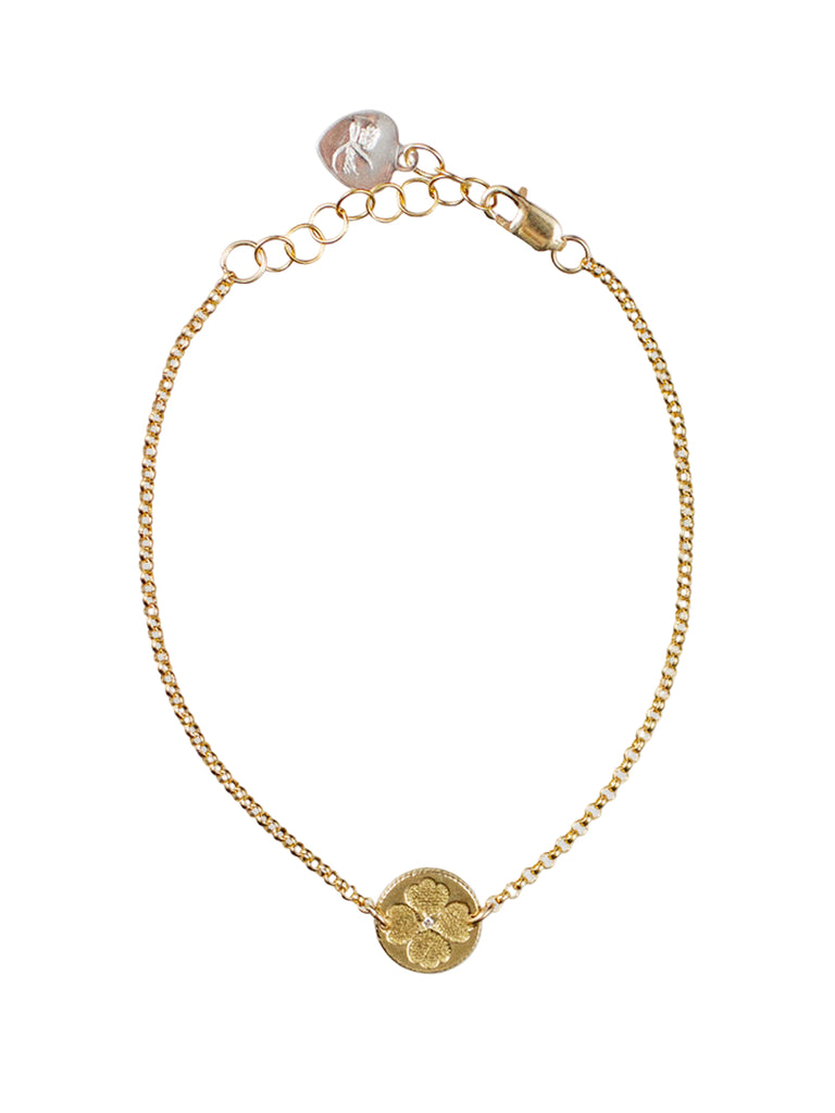 Gold bracelet with a coin charm on a white background