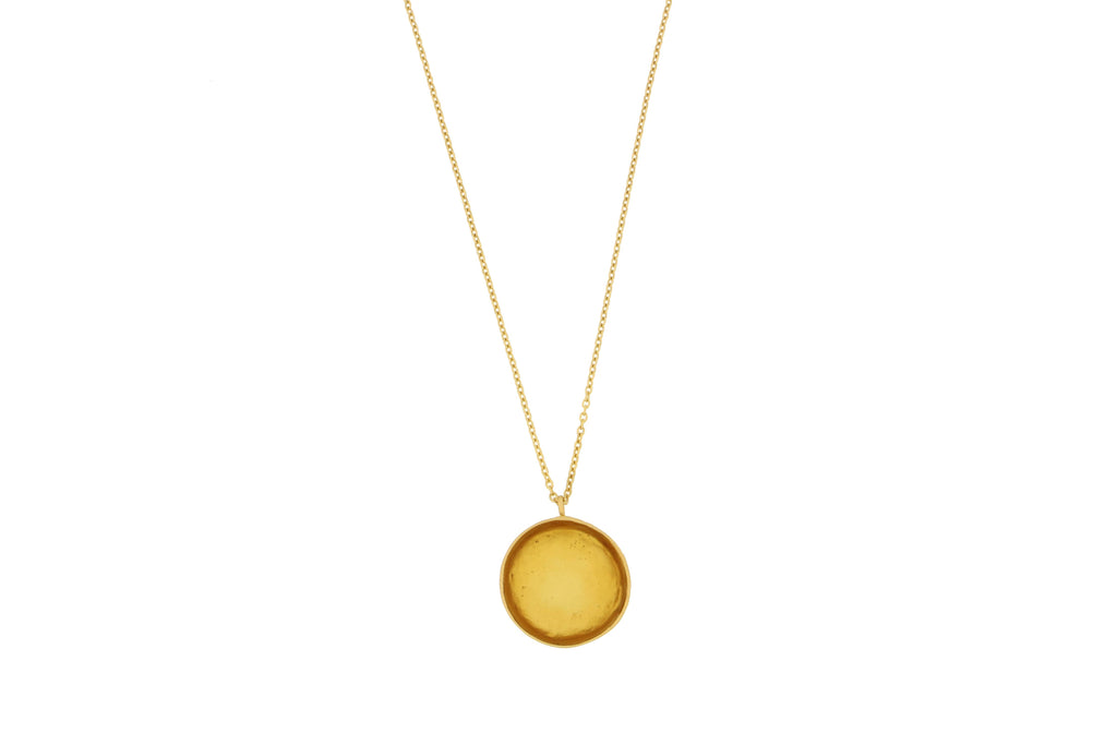 Gold necklace with a round Amber pendant on a white background