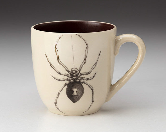 Ceramic mug with a spider design on a plain background