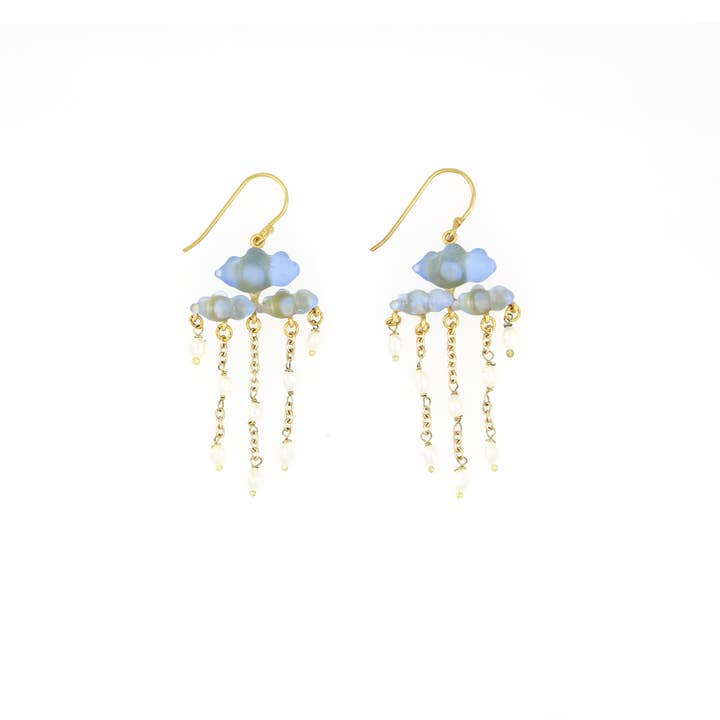 Pair of earrings with cloud-shaped glass and gold chains wityh dangling pearls on a white background