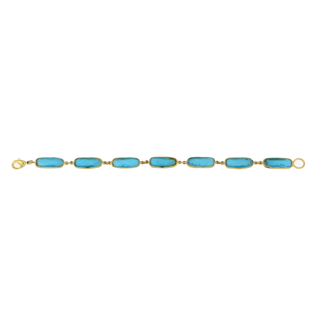 Gold bracelet with blue stones on a white background