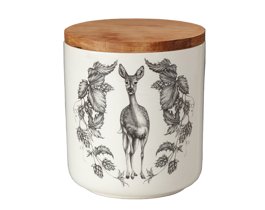 White ceramic jar with wooden lid featuring black and white illustrations of a deer and leaves on a gray background.