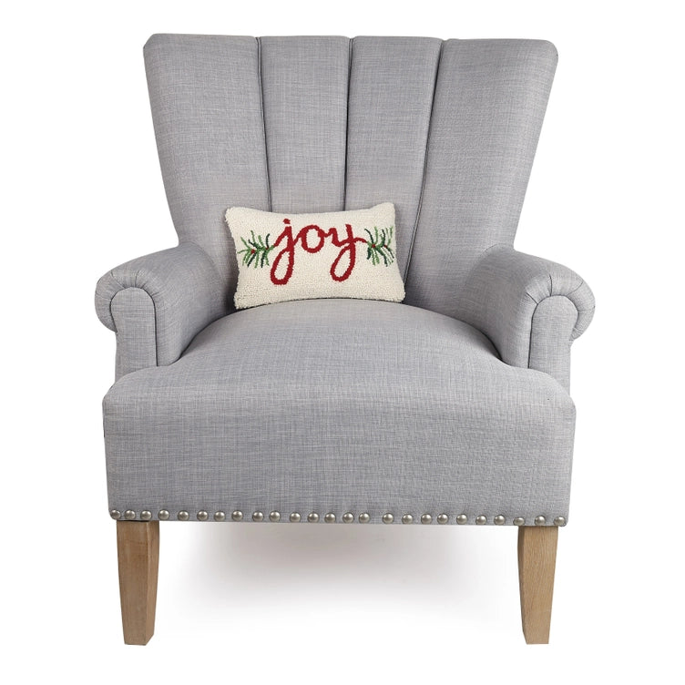 Gray armchair with a 'joy' pillow on a white background