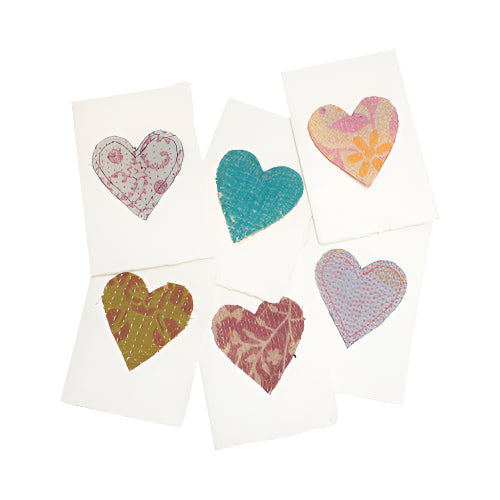 A collection of various designed heart-shaped patches on paper, featuring different patterns and colors.
