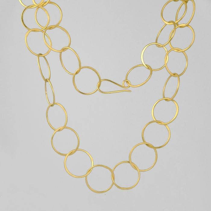 Gold chain necklace on a light gray background