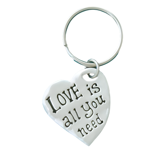 Heart-shaped keychain with 'I Love is all you need' text on a white background