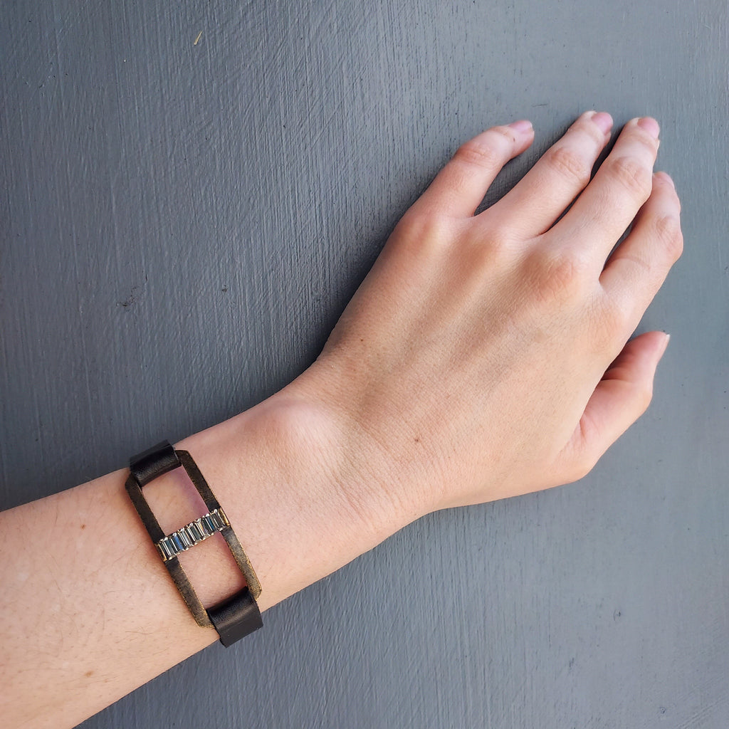 Open Rectangle Baguette Bar Bracelet on hand model over blue background