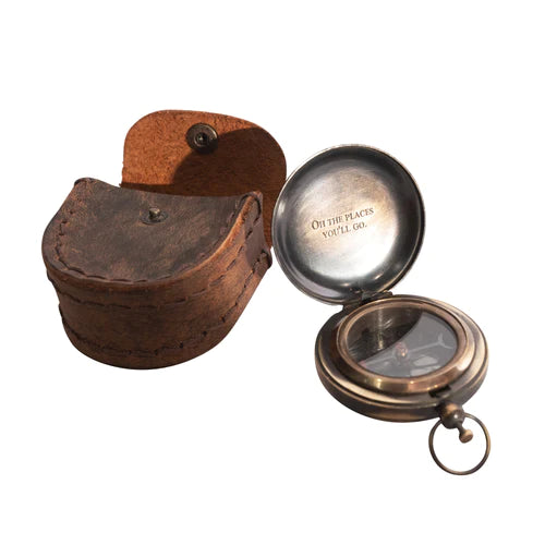 Open compass with "Oh the Places You'll Go" on the inside next to a leather compass case
