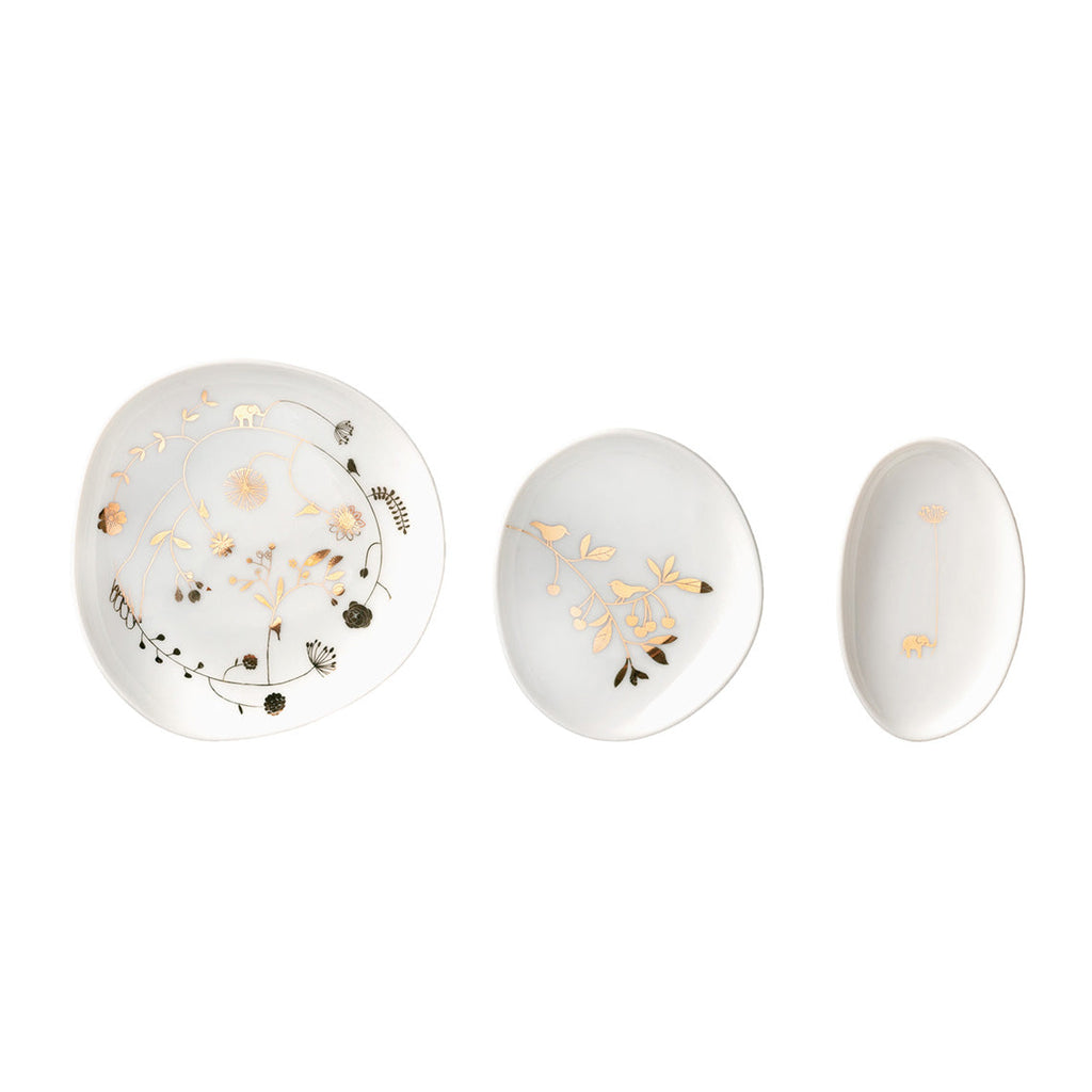 Three white oval plates with decorative gold and black patterns on a white background