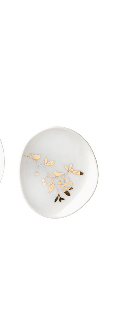 Decorative white plate with gold leaf design on a white background