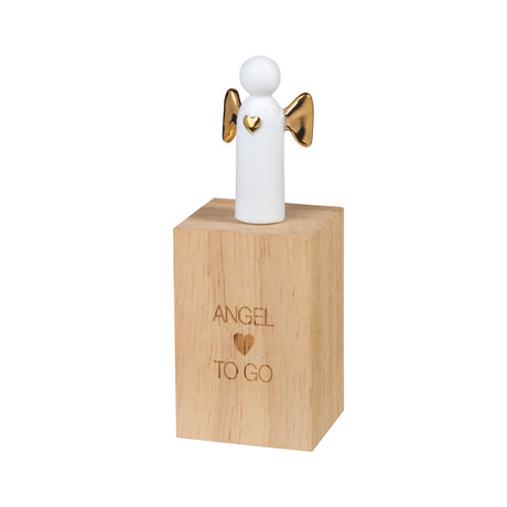 White angel figurine with gold wings on a wooden box with 'Angel To Go' engraving.