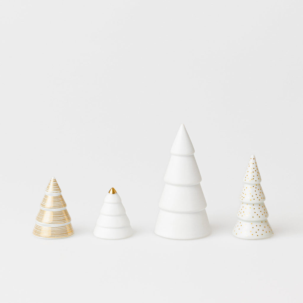 four ceramic Christmas tree ornaments on a white background