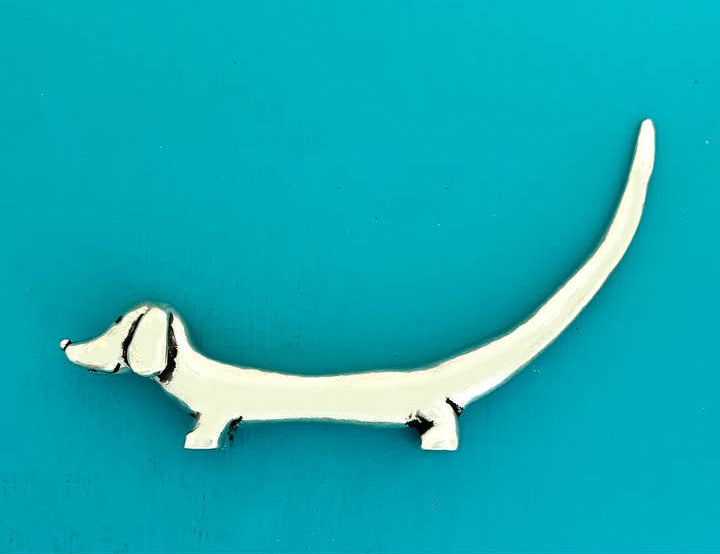 Metallic dog-shaped object on a teal background