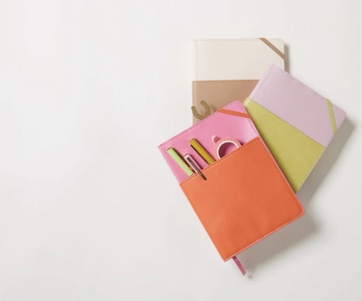 Colorful stationery set with notebooks and pens on a light background