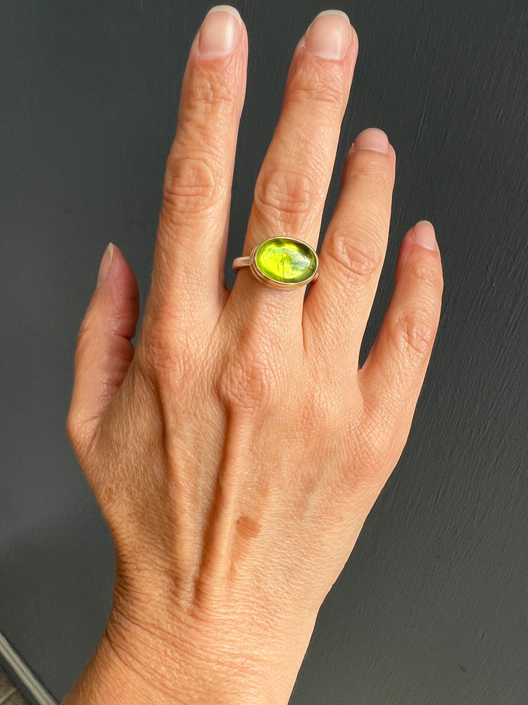 Smooth Oval Peridot Ring on hand