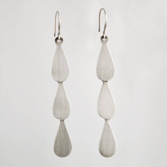 Pair of silver teardrop-shaped earrings on a light gray background