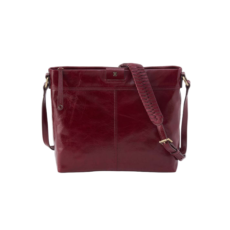 Maroon leather handbag with a strap on a white background