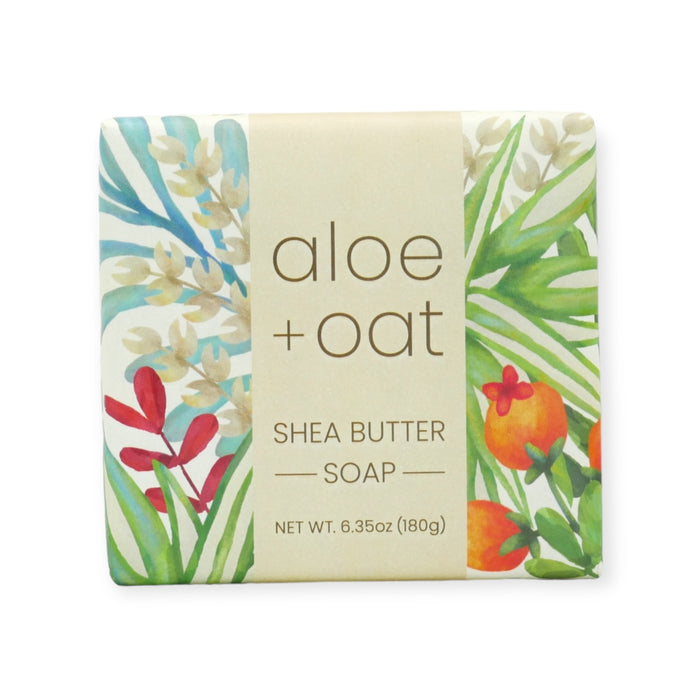 aloe & oat bar soap wrapped in vibrant floral paper on a white background