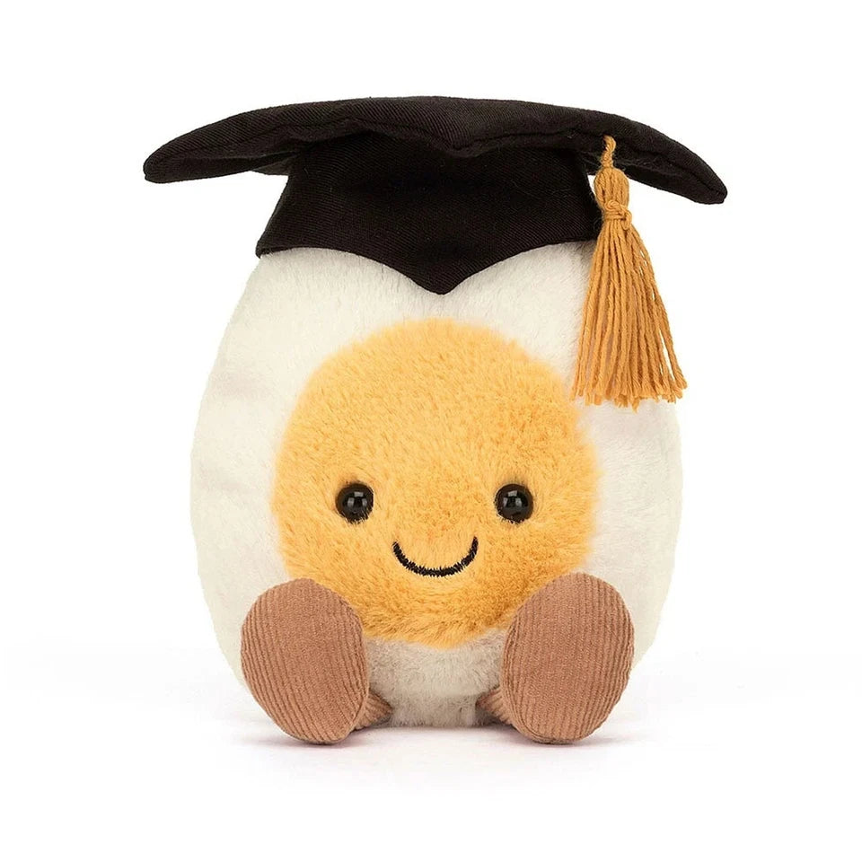 smiling stuffed hard boiled egg with legs and wearing a graduation cap