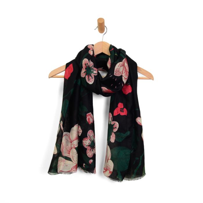 Black floral scarf on a wooden hanger against a white background