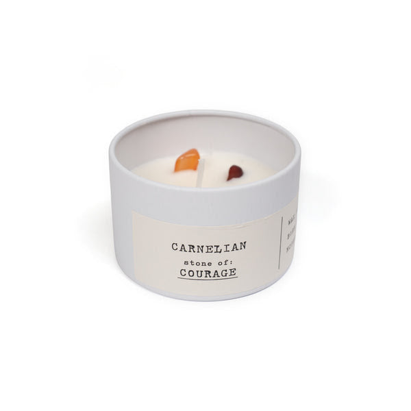 Candle in a white container with 'Carnelian stone of courage' text on a white background
