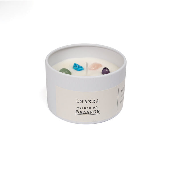 Candle in a white container with 'Chakra stones of Balance' text on a white background