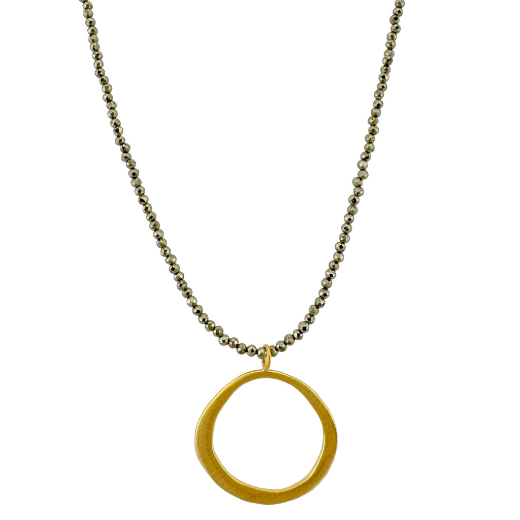 Gold circular pendant on beads against a white background