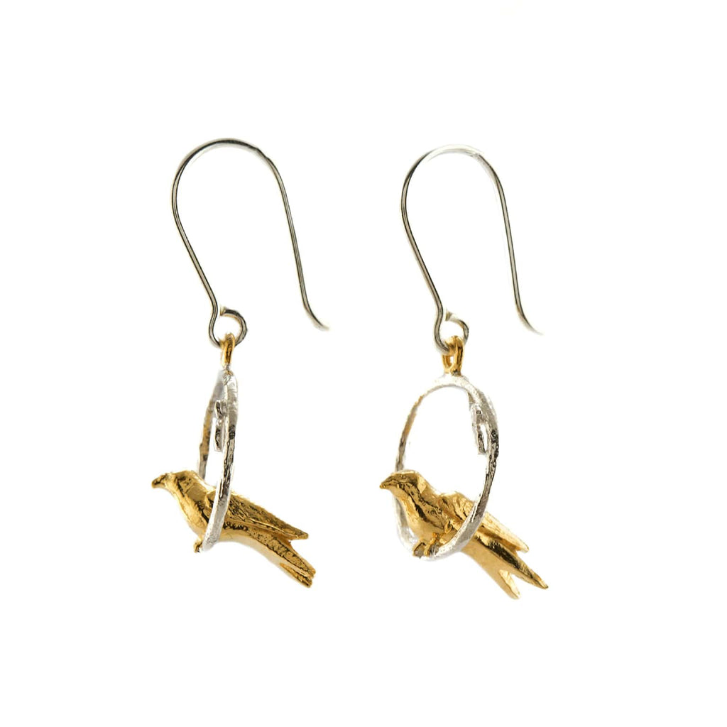 Gold and silver bird-shaped earrings on a white background