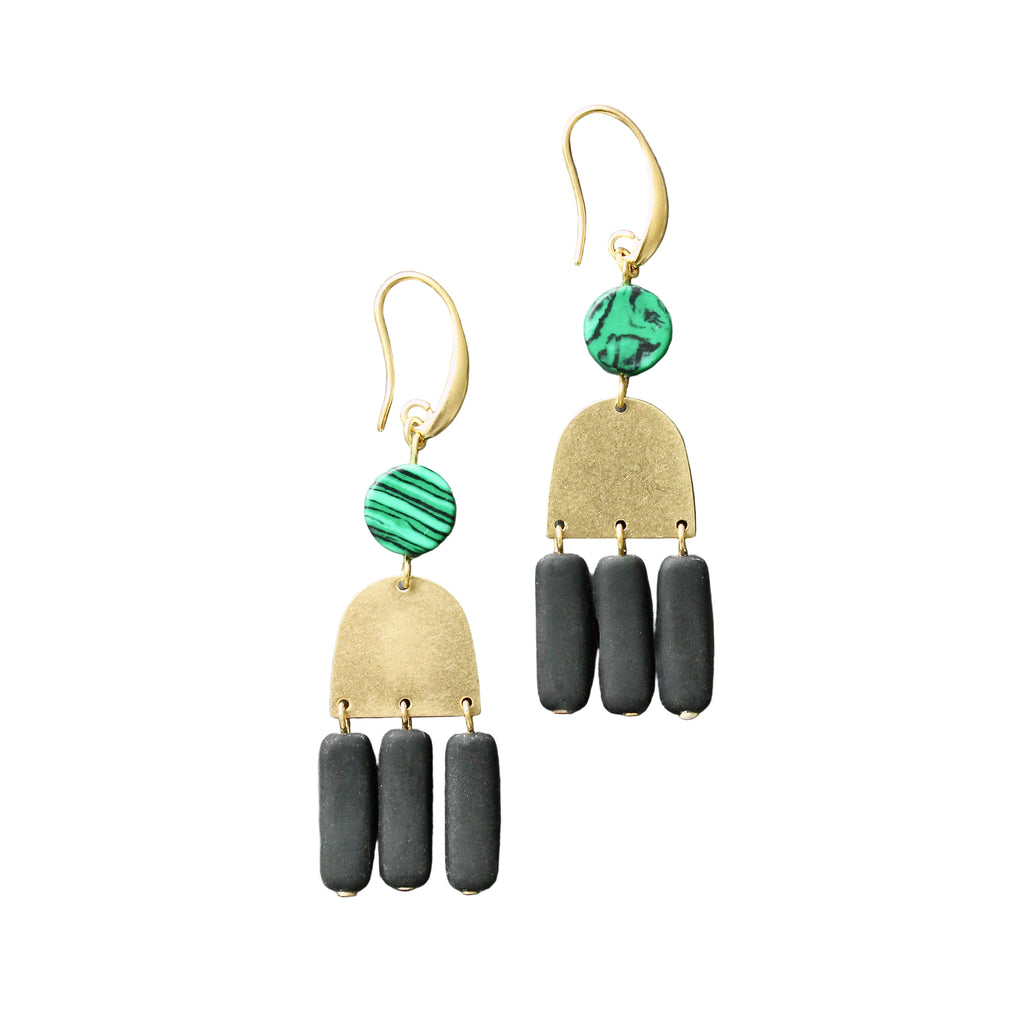 Pair of earrings with gold, green, and black components on a gray background