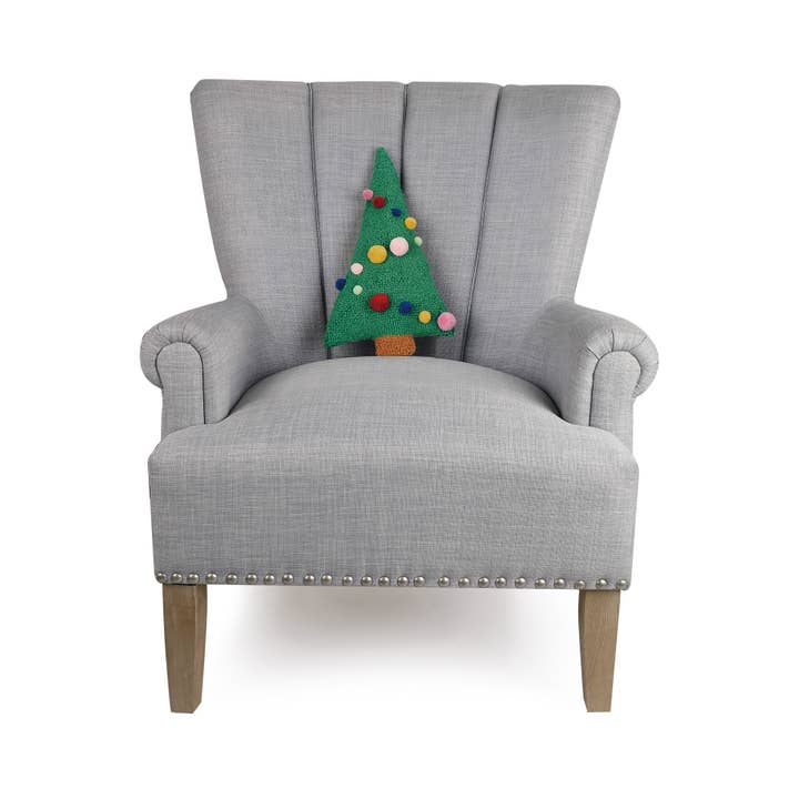 Gray armchair with a decorative pillow shaped like a Christmas tree on a white background