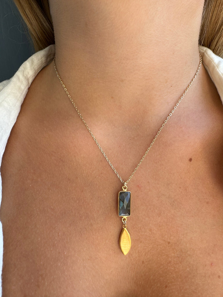Gold chain necklace with a pendant on a person's neck
