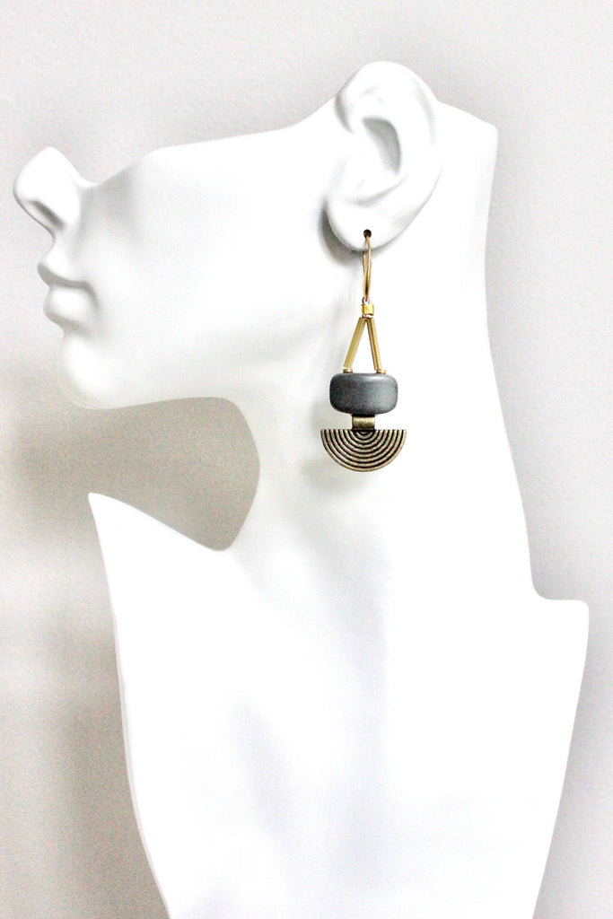 Earring on a mannequin ear with a white background