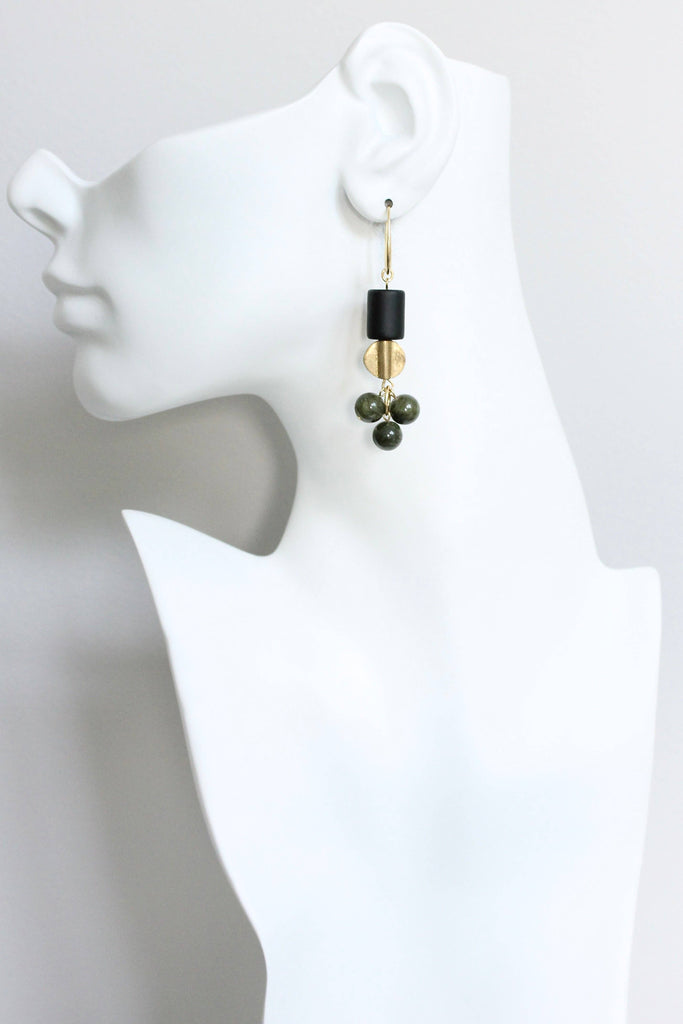 Earring displayed on a mannequin ear with a white background