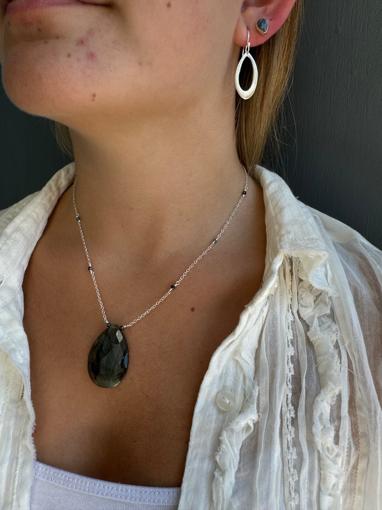 Necklace with a large pendant worn by a person, close-up view.